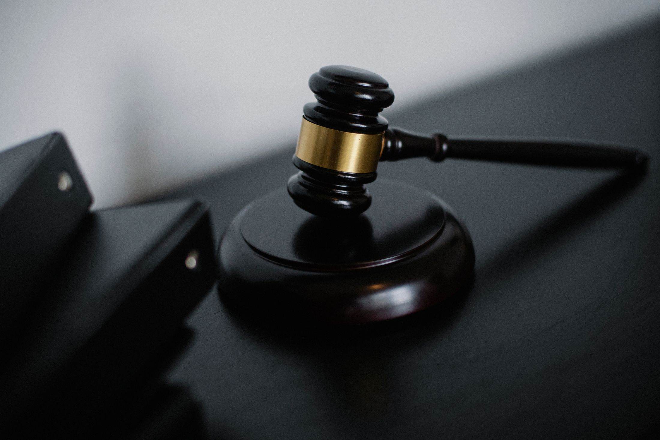 A wooden auctioneer’s gavel resting on its block