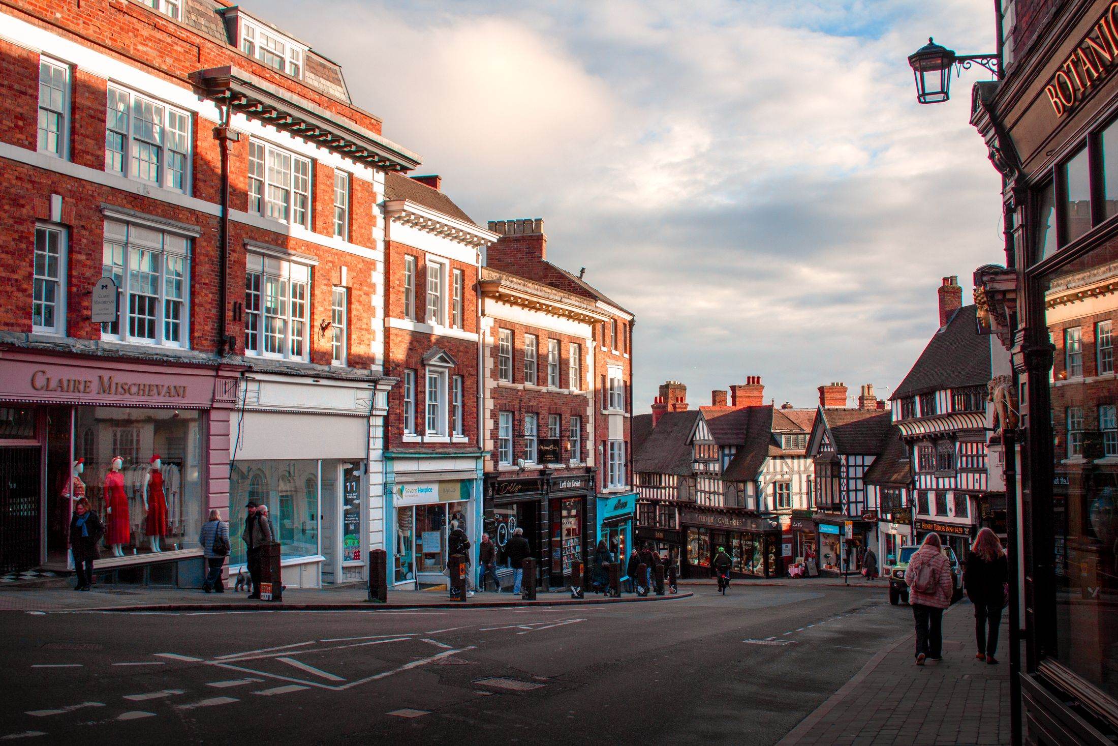 A historic high street in Shrewsbury with shops on the ground floor and flats above
